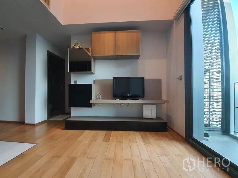 公寓 出租或出售在Khlong Toei, Bangkok - 起居区电视柜与壁柜，旁为通往阳台的玻璃门。