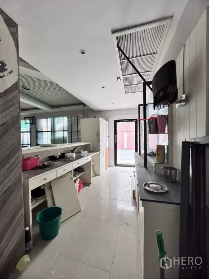 Retail Space for rent in Watthana, Bangkok - Back-of-house prep area with long counter, shelving and a door leading to the exterior.