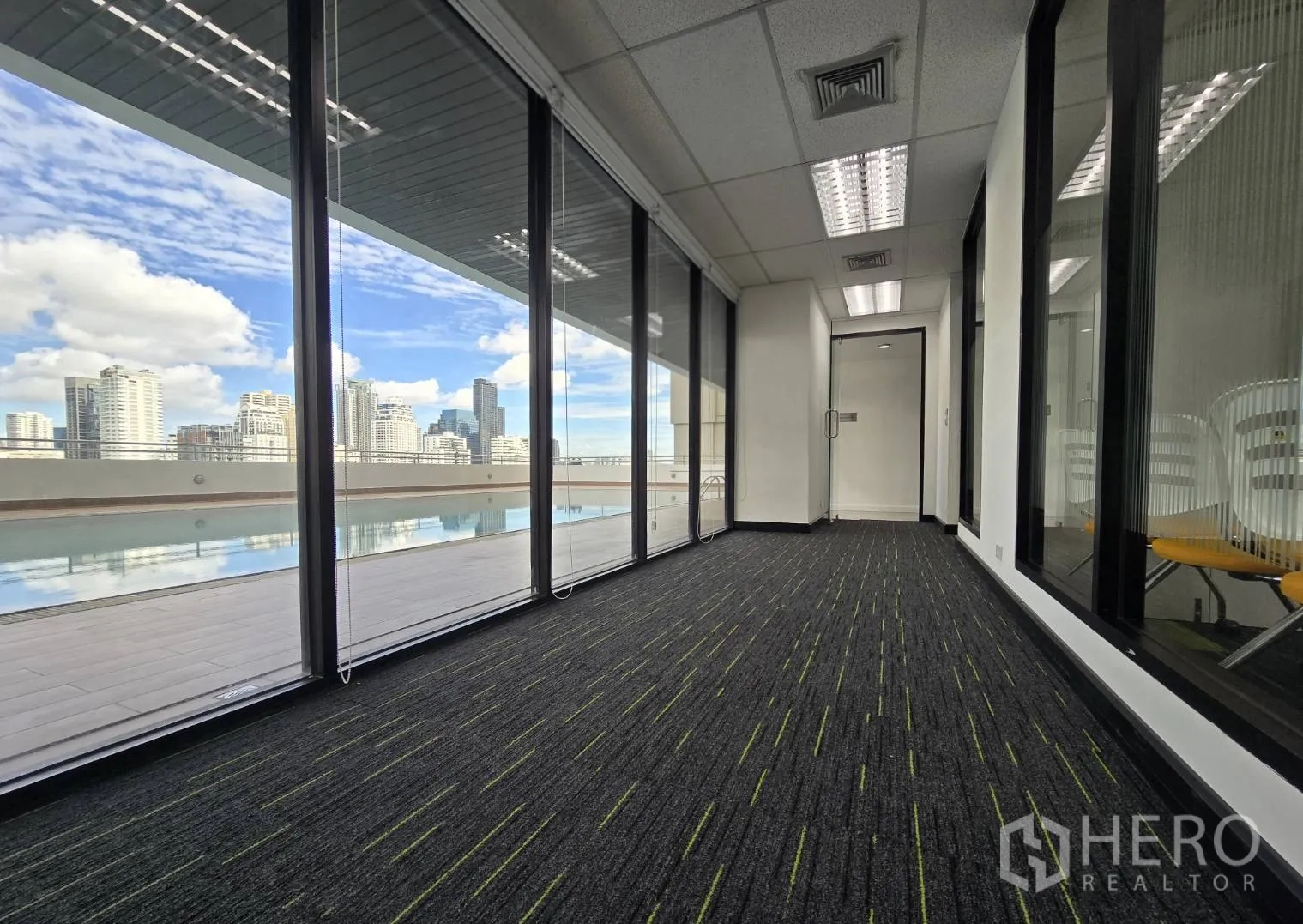 ออฟฟิศ for rent in Watthana, Bangkok - ทางเดินมีผนังกระจกเต็มความสูง มองเห็นสระว่ายน้ำและวิวเมือง.