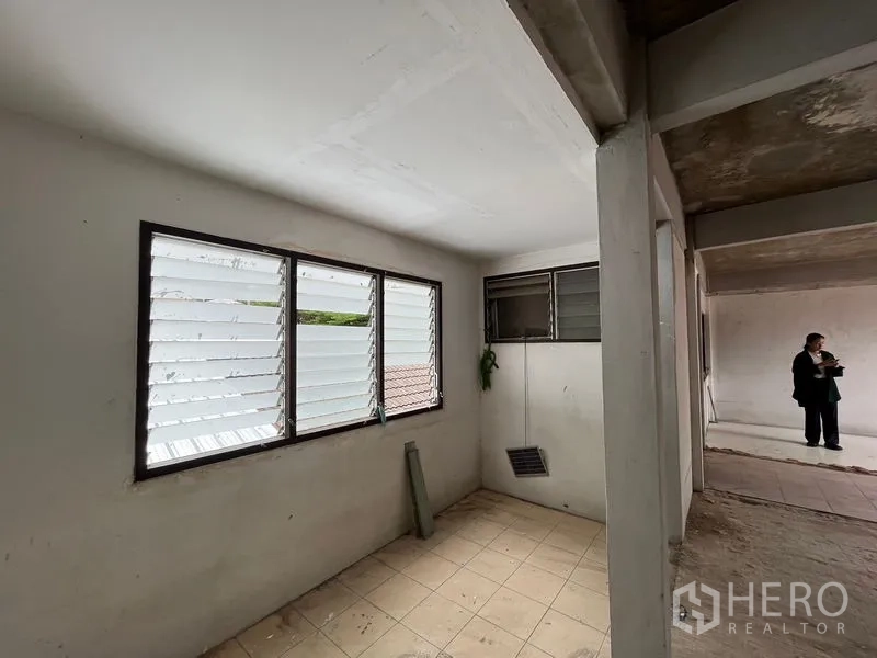 Retail Space for rent in Watthana, Bangkok - Compact room with tiled floor and louvered windows adjoining the main hall.