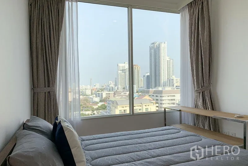 公寓 出租在Watthana, Bangkok - 第二卧室设大窗与窗帘，享城市景观。