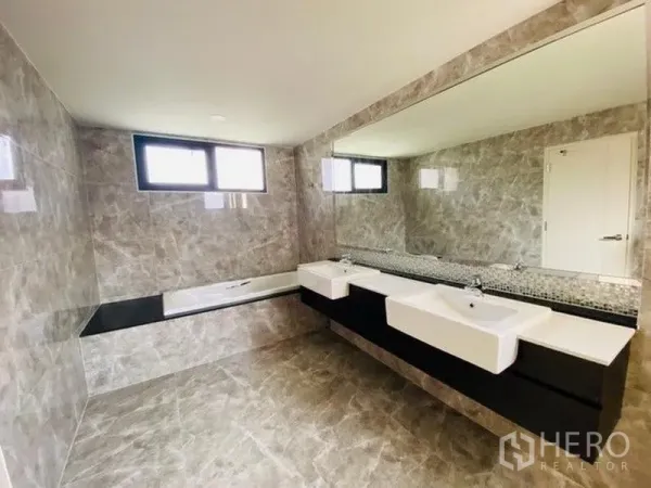 บ้าน ขายในBang Phli, Samut Prakan - ห้องน้ำสไตล์ลักชัวรี มีอ่างอาบน้ำ อ่างล้างหน้าคู่ และกระจกเต็มผนัง พื้นผิวลายหิน