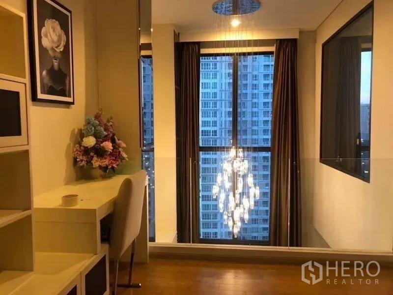 公寓 出租在Ratchathewi, Bangkok - 书桌临窗，俯视水晶吊灯与黄昏城市景观。