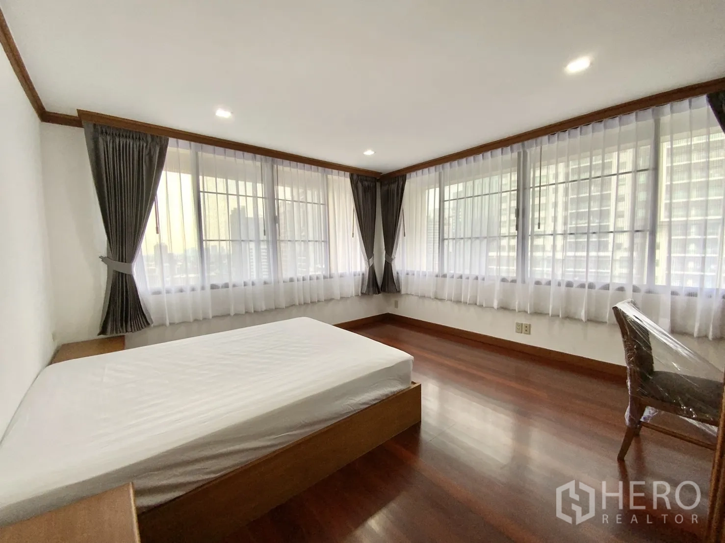 公寓 出租在Watthana, Bangkok - 转角卧室，整面窗帘与城市景观。