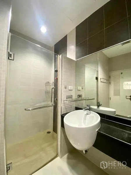 公寓 出租或出售在Bang Kapi, Bangkok - 现代浴室，玻璃淋浴间、圆形台盆与大镜子。