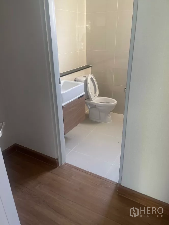 Detached House for rent or sale in Saphan Sung, Bangkok - Modern bathroom with tiled walls, vanity and toilet.