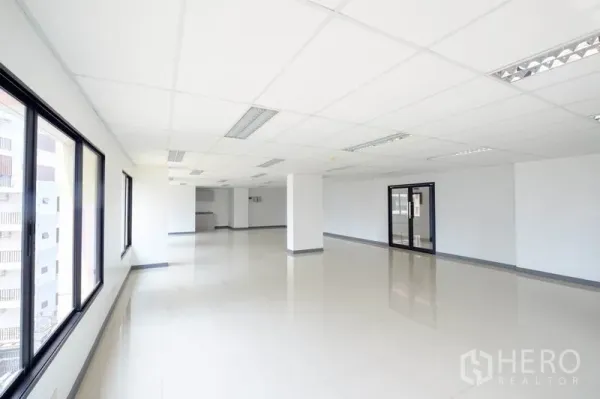 Office Space for rent in Chatuchak, Bangkok - Spacious open‑plan office with drop ceiling, tiled floors, and large windows.