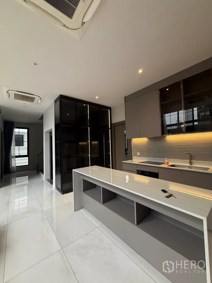 Detached House for rent in Saphan Sung, Bangkok - Sleek open kitchen with long island, built-in cabinets and accent lighting.