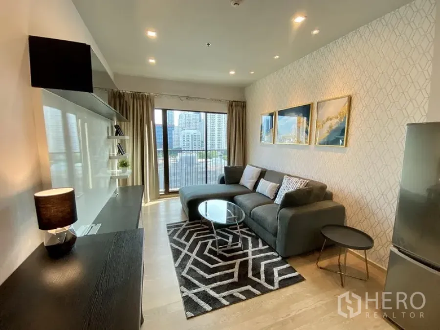 Condominium for rent in Bangkok - Bright lounge with floor-to-ceiling windows, balcony and city skyline view.