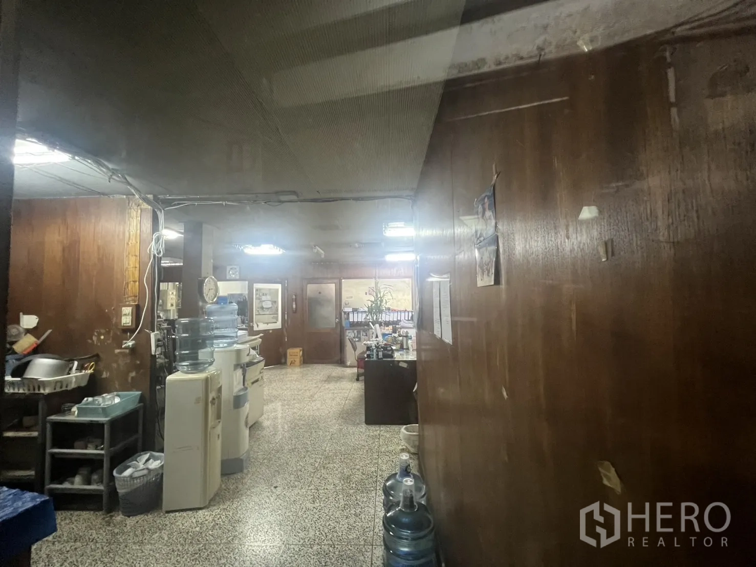 店屋 出租 - 后勤工作区，木质墙面、设备与水磨石地面。