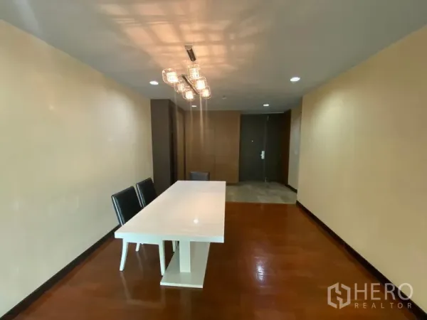 公寓 出租在Watthana, Bangkok - 用餐区设长条白色餐桌与吊灯，木地板光亮。
