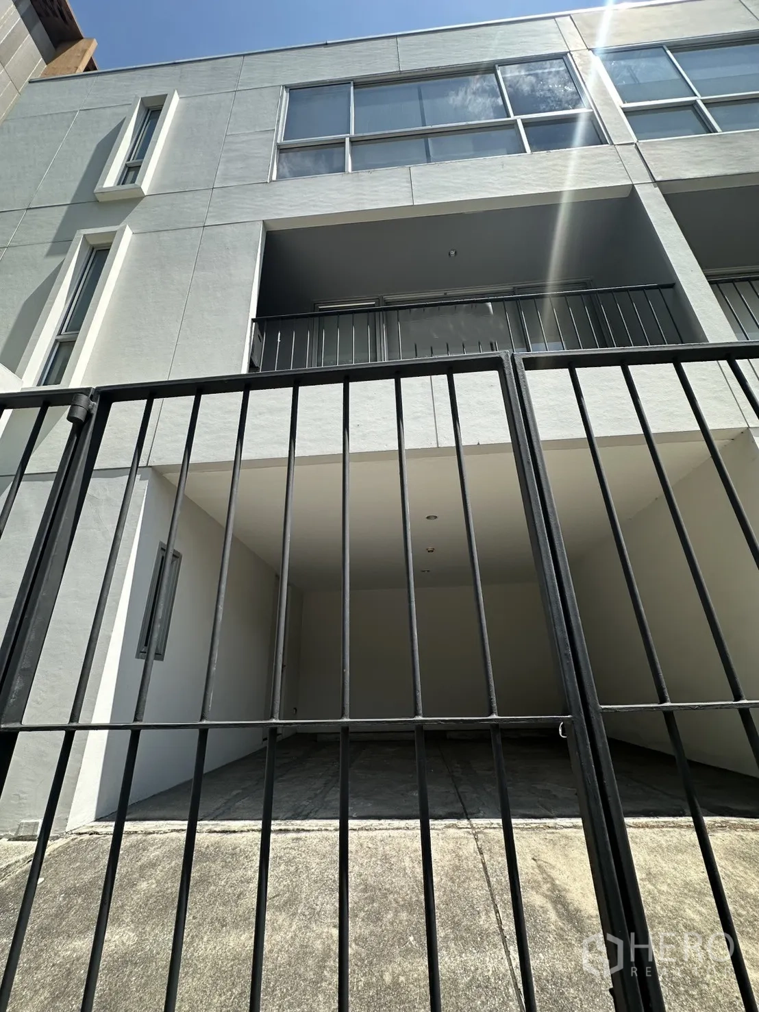 โฮมออฟฟิศ for rent in Phra Khanong, Bangkok - มองผ่านประตูรั้วเหล็กเห็นระเบียงและหน้าต่างบานใหญ่ของอาคาร.
