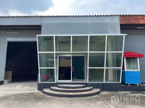 Warehouse for rent in Sam Phran, Nakhon Pathom - Close-up of the glass entrance pavilion with curved steps leading to the warehouse lobby.