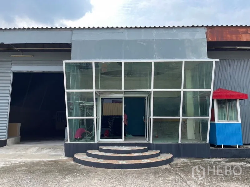 Warehouse for rent in Sam Phran, Nakhon Pathom - Close-up of the glass entrance pavilion with curved steps leading to the warehouse lobby.