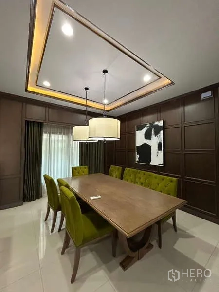 Detached House for rent in Bang Kapi, Bangkok - Formal dining room with long wooden table, green chairs, and pendant lights.