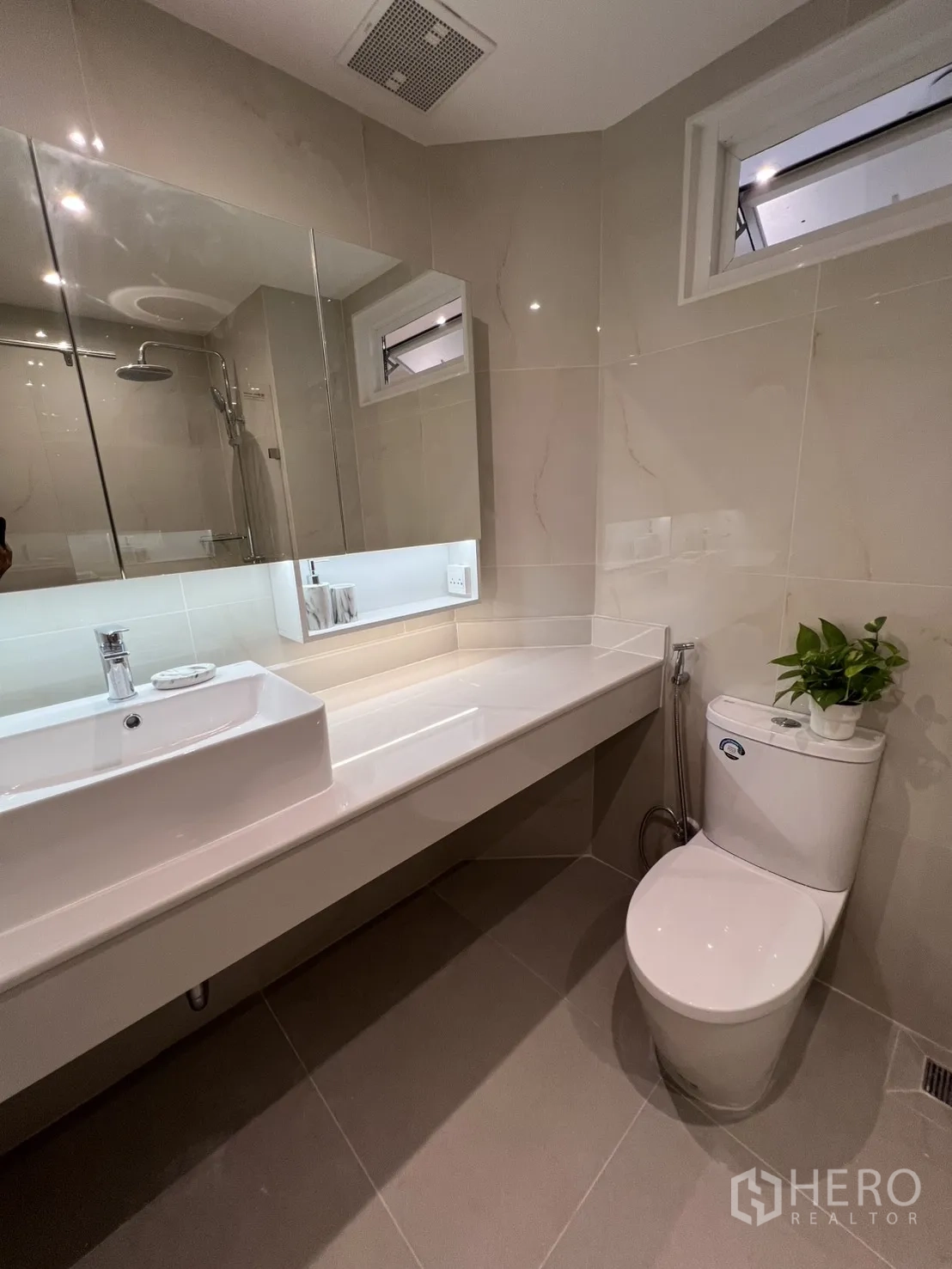Condominium for rent in Yan Nawa, Bangkok - Contemporary bathroom with wide vanity, mirror cabinets, and toilet.