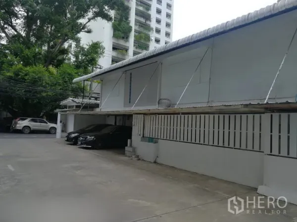 Retail Space for rent in Khlong Toei, Bangkok - On-site parking courtyard beside a single-storey commercial building with covered bays.
