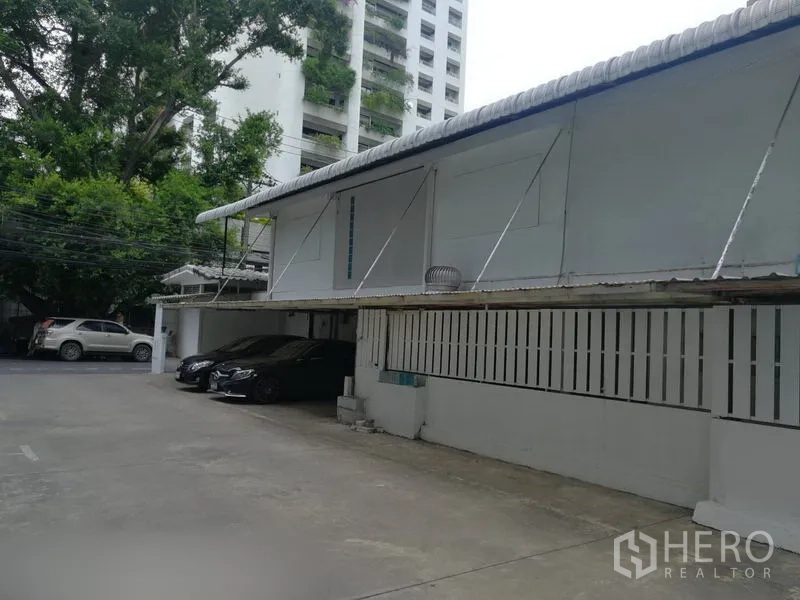 Retail Space for rent in Khlong Toei, Bangkok - On-site parking courtyard beside a single-storey commercial building with covered bays.