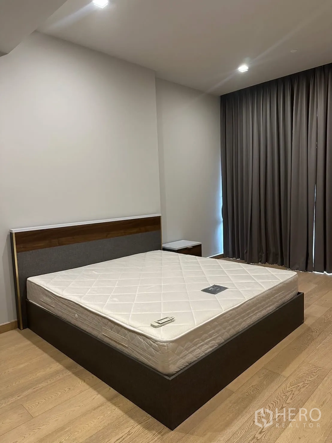 คอนโด for rent or sale in Watthana, Bangkok - ห้องนอนแขกเตียงควีน พื้นไม้ และผ้าม่านทึบแสง.
