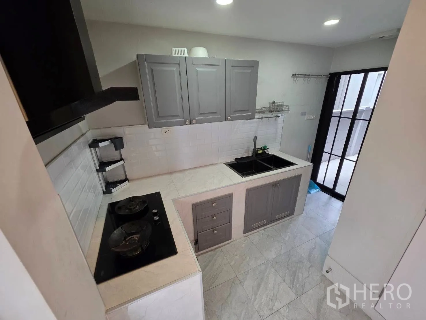 独栋房屋 for rent or sale in Bang Phli, Samut Prakan - 灰色橱柜的紧凑厨房，双水槽、炉灶并通向后院。