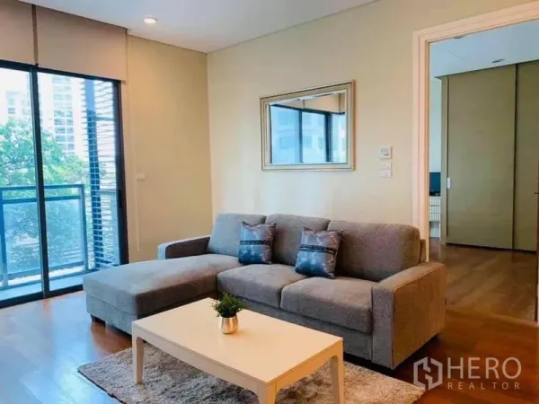 公寓 出租在Khlong Toei, Bangkok - Bright Sukhumvit 24 客厅，灰色转角沙发、茶几与可观城市绿景的阳台。