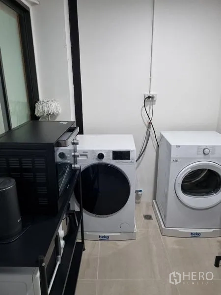 Townhouse for rent - Laundry room with front-loading washer and dryer beside shelving.