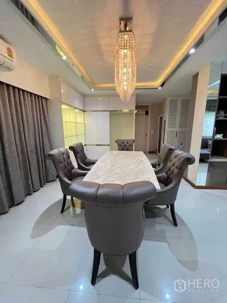 Detached House for sale in Bang Kruai, Nonthaburi - Elegant dining room featuring a marble-top table, tufted chairs, and a statement chandelier.