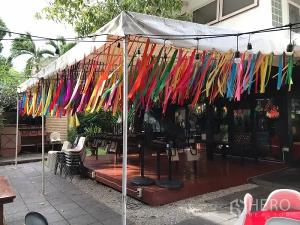 Retail Space for rent in Watthana, Bangkok - Outdoor deck under a canopy with colorful streamers and a garden backdrop.