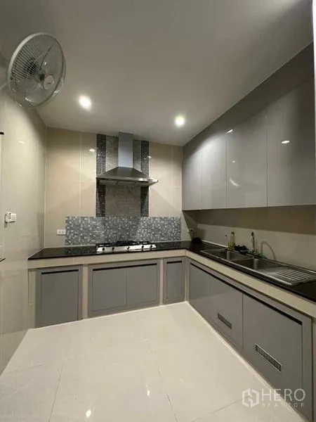 独立式住宅 出售在Prawet, Bangkok - 封闭式厨房，灰色橱柜，燃气灶与抽油烟机。