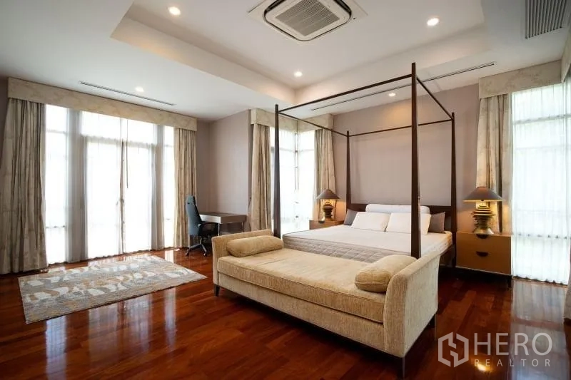 独立式住宅 出租在Watthana, Bangkok - 宽敞主卧，四柱床与贵妃椅，木地板光亮。