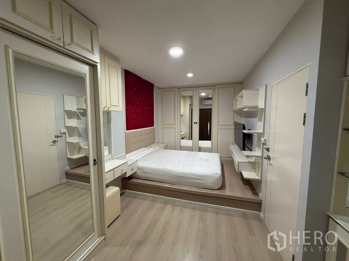Townhouse for rent in Suan Luang, Bangkok - Master bedroom with platform bed, mirrored wardrobes and dressing area.