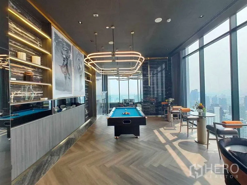 Condominium for rent in Watthana, Bangkok - Sky lounge with a pool table, statement lighting, and panoramic windows.