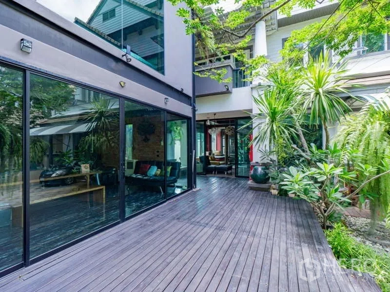 独立式住宅 出售在Suan Luang, Bangkok - 庭院空间，宽阔木平台与通高玻璃墙面。
