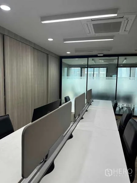 带办公室的家 出租在Bueng Kum, Bangkok - 前台休息区阳光充足，沙发与软墩，街景透过高窗可见。