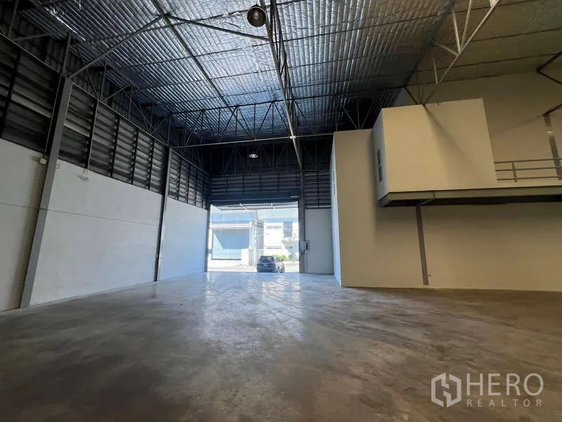 Warehouse for rent in Prawet, Bangkok - Interior view toward a large roller shutter entrance for truck access.
