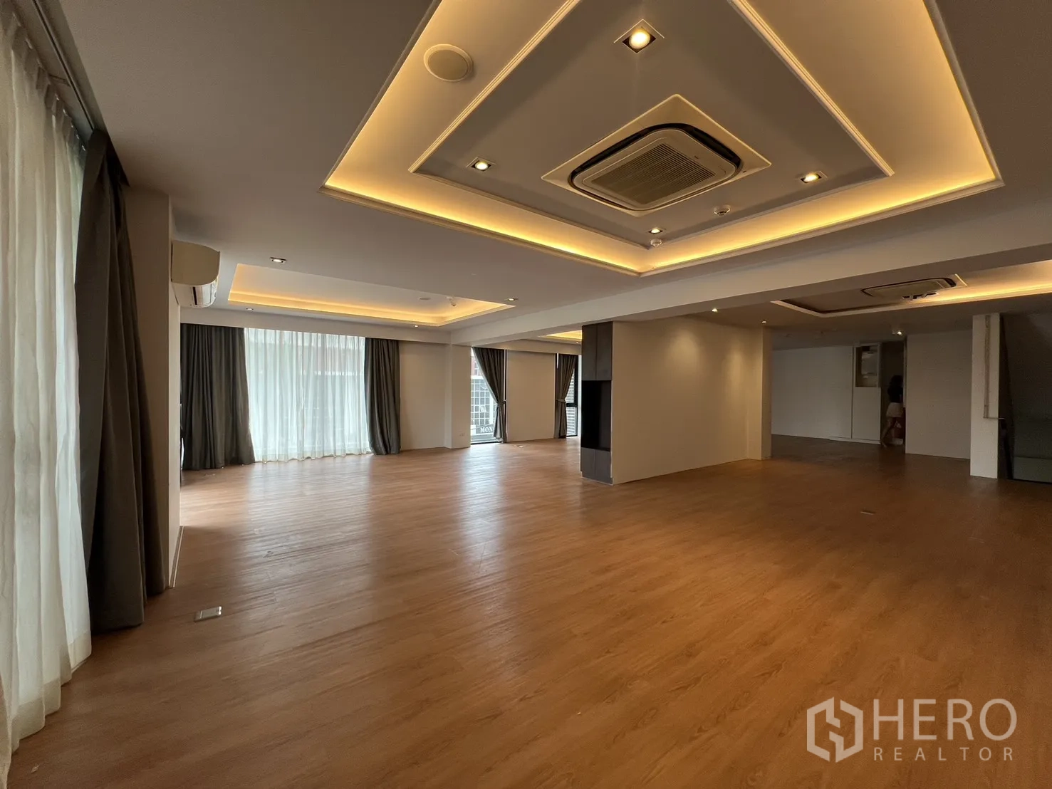 Retail Space for rent in Khlong Toei, Bangkok - Large multipurpose room with ceiling coves, curtains and wood floors.