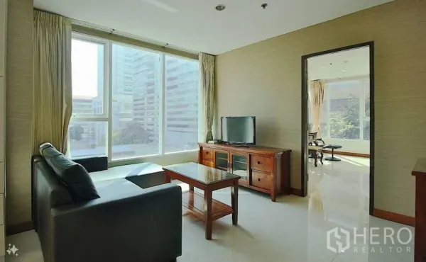 公寓 出售在Watthana, Bangkok - 客厅配电视柜与沙发，落地窗俯瞰阿索克商圈高楼。