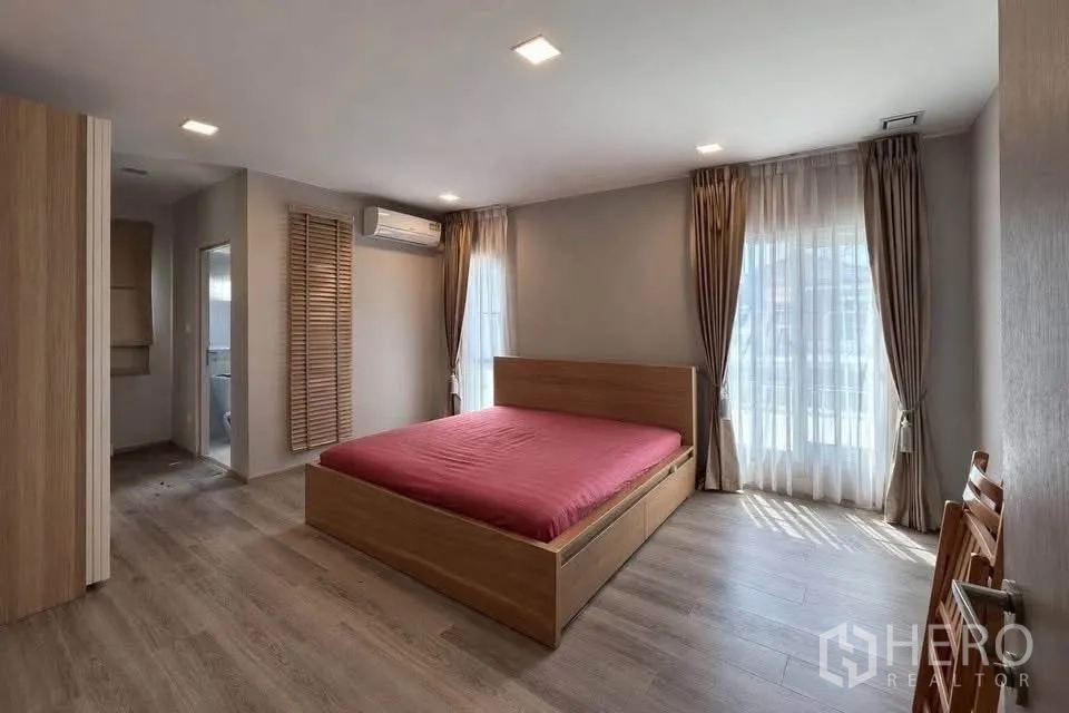 半独立式住宅 for rent in Prawet, Bangkok - 宽敞卧室，木质地板，大窗，并有通往卫生间的门。