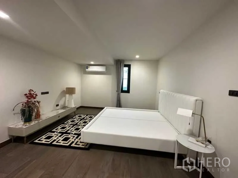 บ้าน ให้เช่าในSuan Luang, Bangkok - ห้องนอนมินิมอล เตียงสีขาว โต๊ะข้าง และพื้นไม้