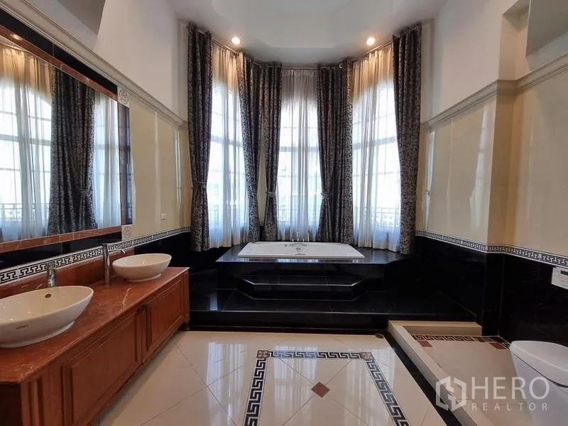 Detached House for rent in Yan Nawa, Bangkok - Luxury bathroom with double vanity, large mirrors and a raised soaking tub framed by tall windows.