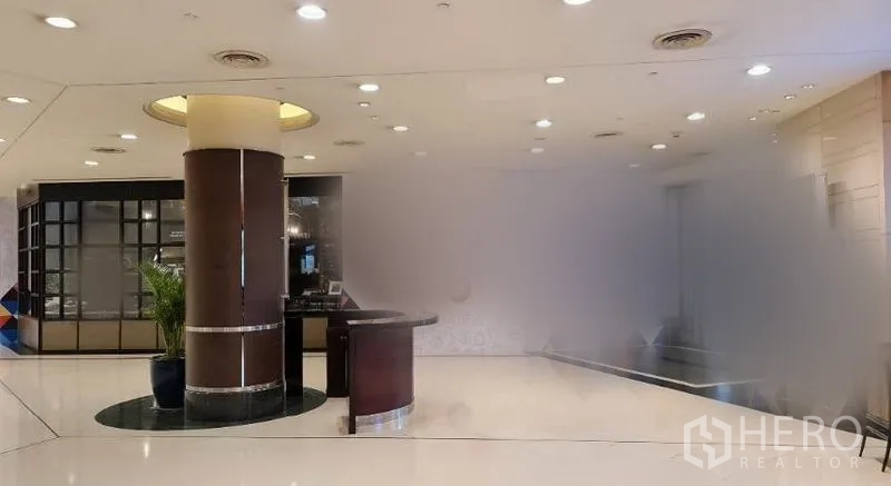 Retail Space for rent in Pathum Wan, Bangkok - Bright retail lobby with glossy white flooring, recessed ceiling lights, round column and reception counter.