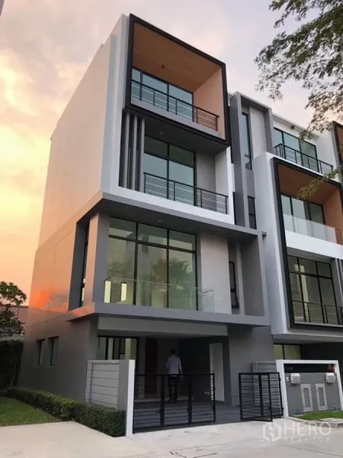 Townhouse for rent or sale in Suan Luang, Bangkok - Another view of the modern townhouse exterior with gated carport and balconies.