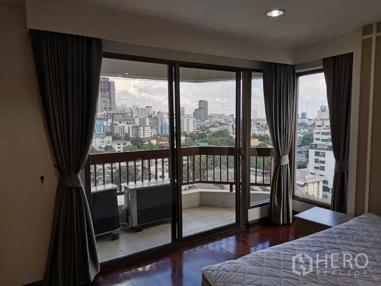 Condominium for rent in Phaya Thai, Bangkok - Bedroom opening to a balcony through sliding glass doors with panoramic city views.