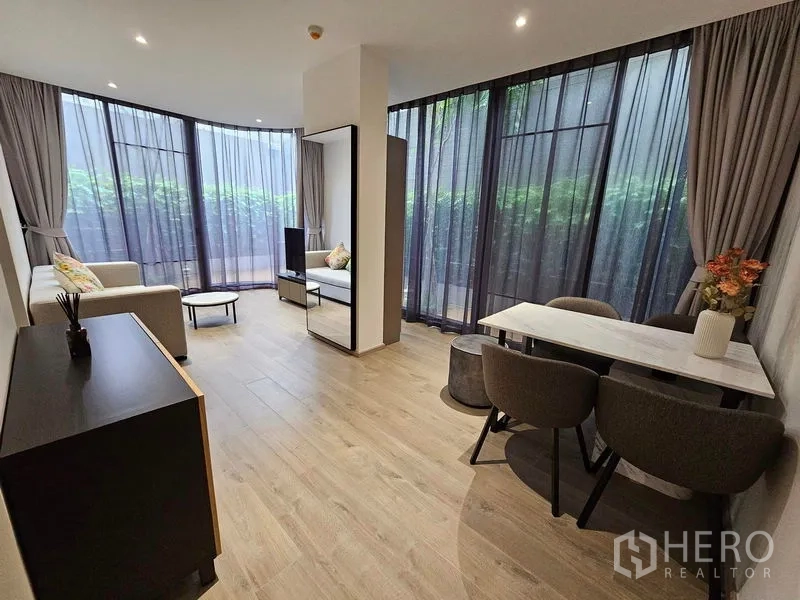 Condominium for rent or sale - Open-plan lounge and dining area with wide plank floors and wraparound windows.