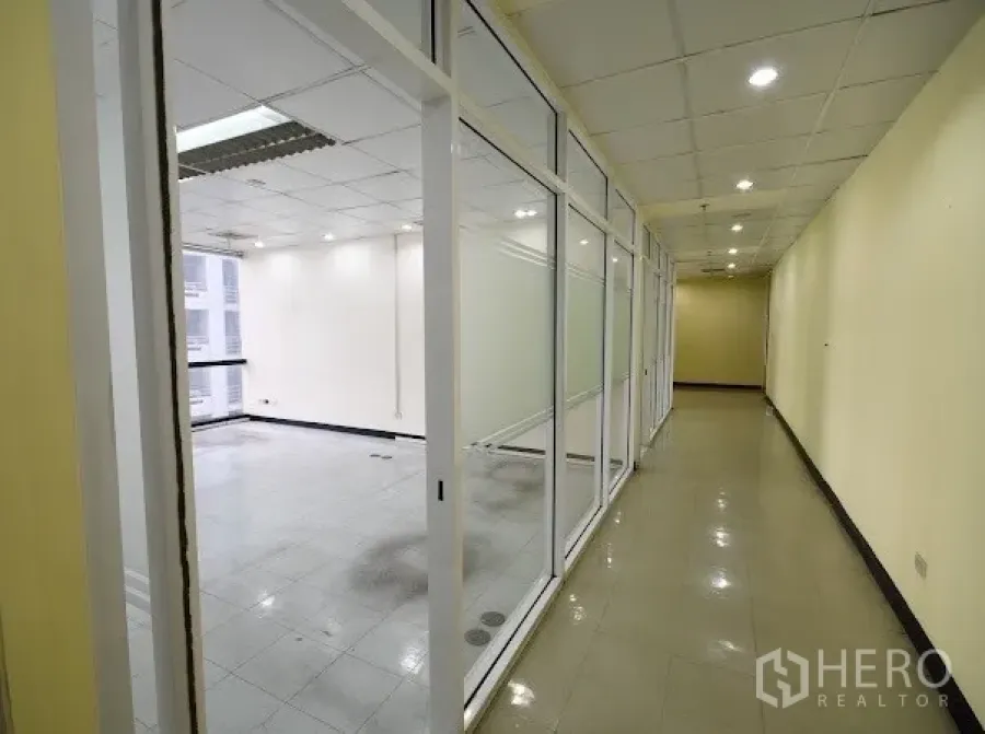 办公空间 出租在Watthana, Bangkok - 素坤逸商务楼内，采光走廊与玻璃隔断办公室及筒灯照明。