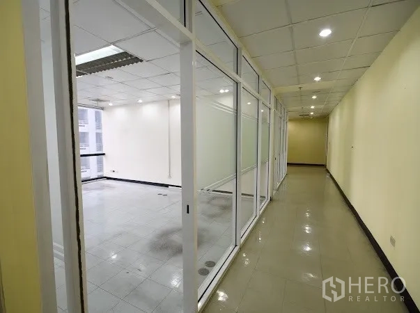 办公空间 出租在Watthana, Bangkok - 素坤逸商务楼内，采光走廊与玻璃隔断办公室及筒灯照明。