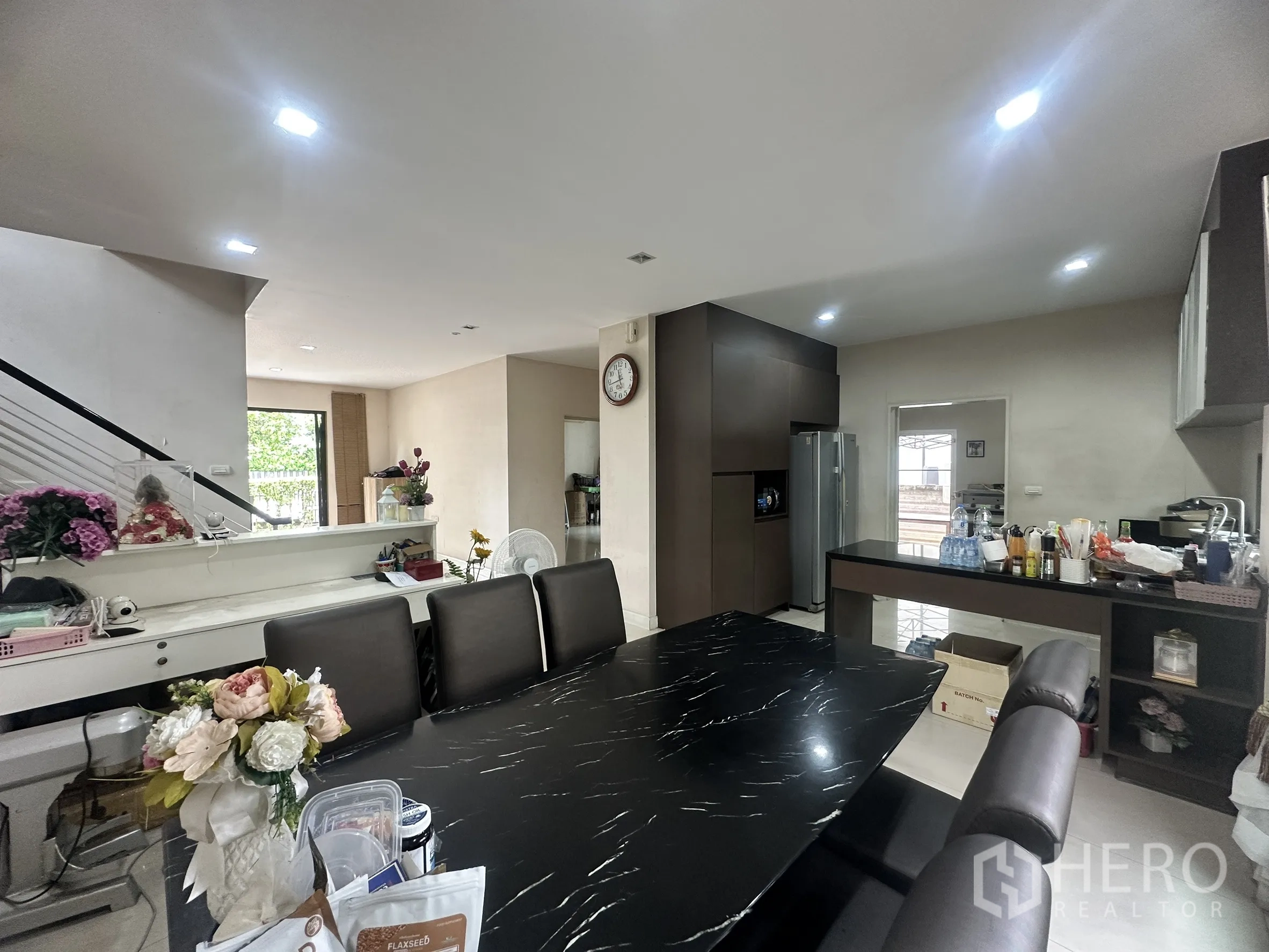 独栋房屋 for sale in Pak Kret, Nonthaburi - 餐区邻近开放式备餐台与深色餐桌、橱柜。
