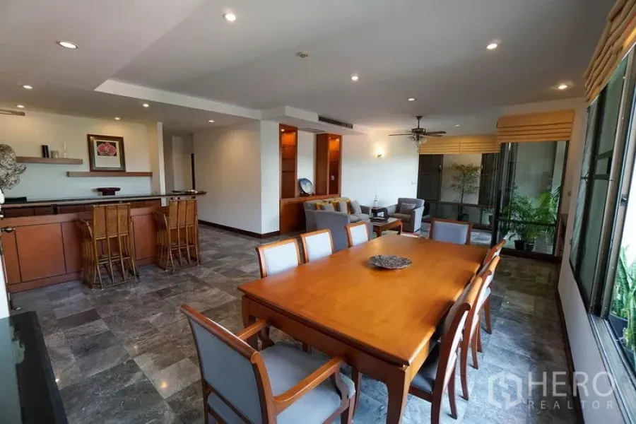 Apartment for rent in Watthana, Bangkok - Dining area and breakfast bar in a spacious open-plan living zone with recessed lighting.