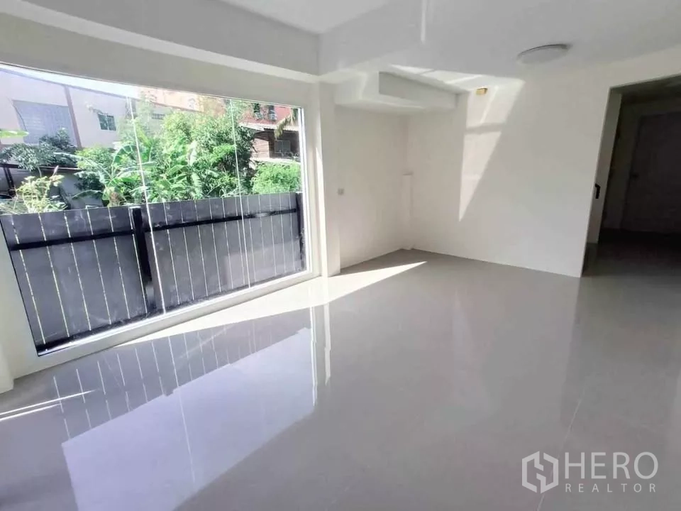 Home Office for rent in Bang Phli, Samut Prakan - Sunlit ground-floor room with large window facing green fencing.