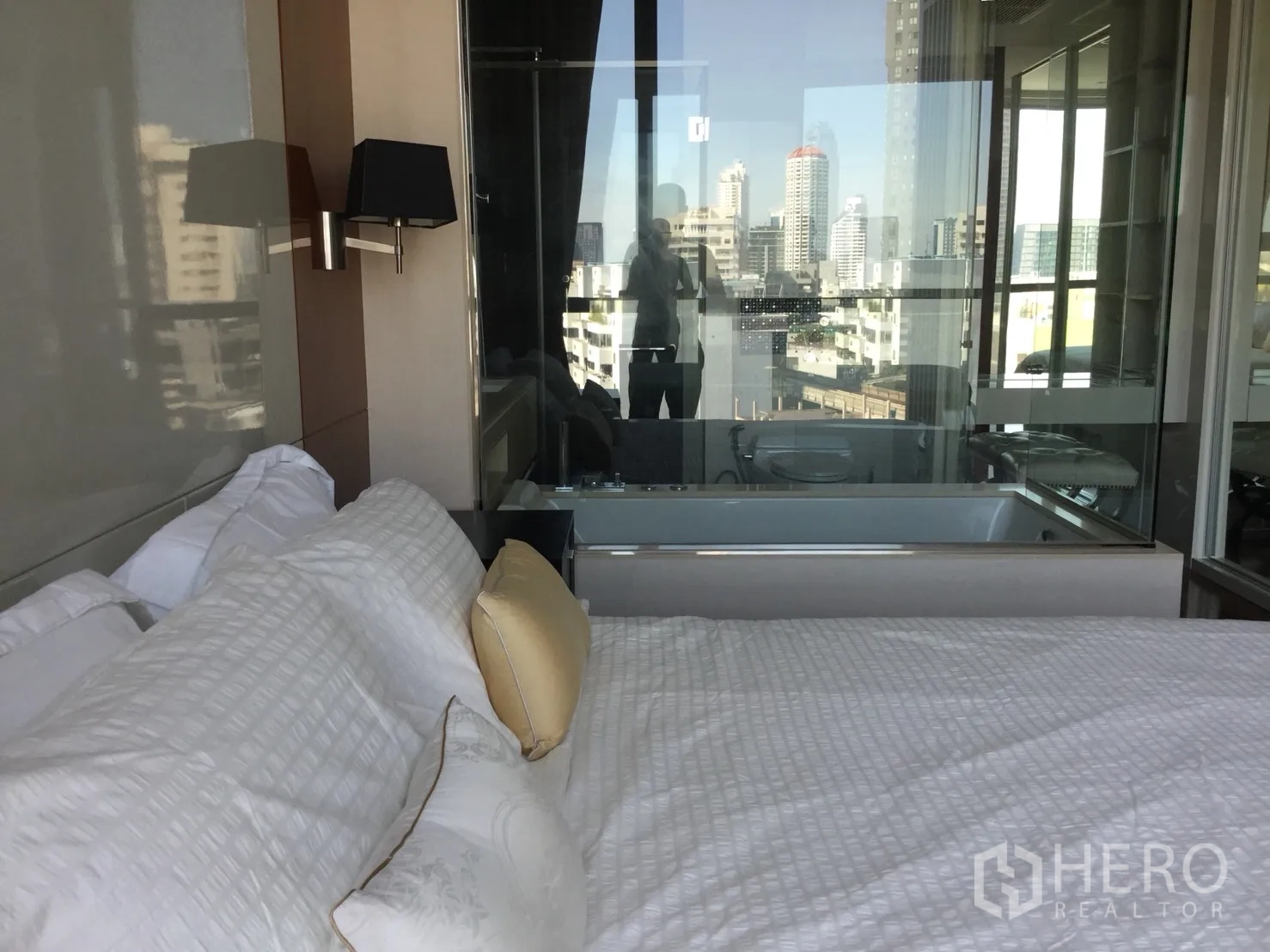Condominium for rent in Khlong Toei, Bangkok - City-view bedroom with glass partition to bathroom featuring a built-in bathtub.